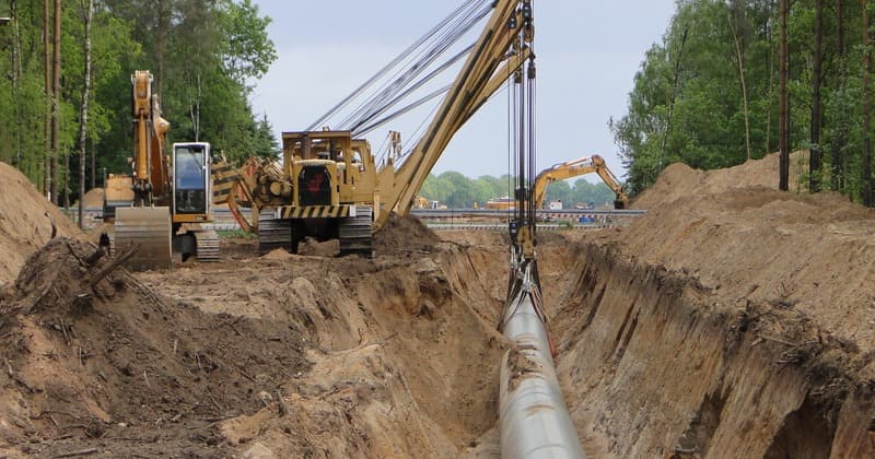 Large-diameter pipeline being laid in a cleared bulk-services corridor
