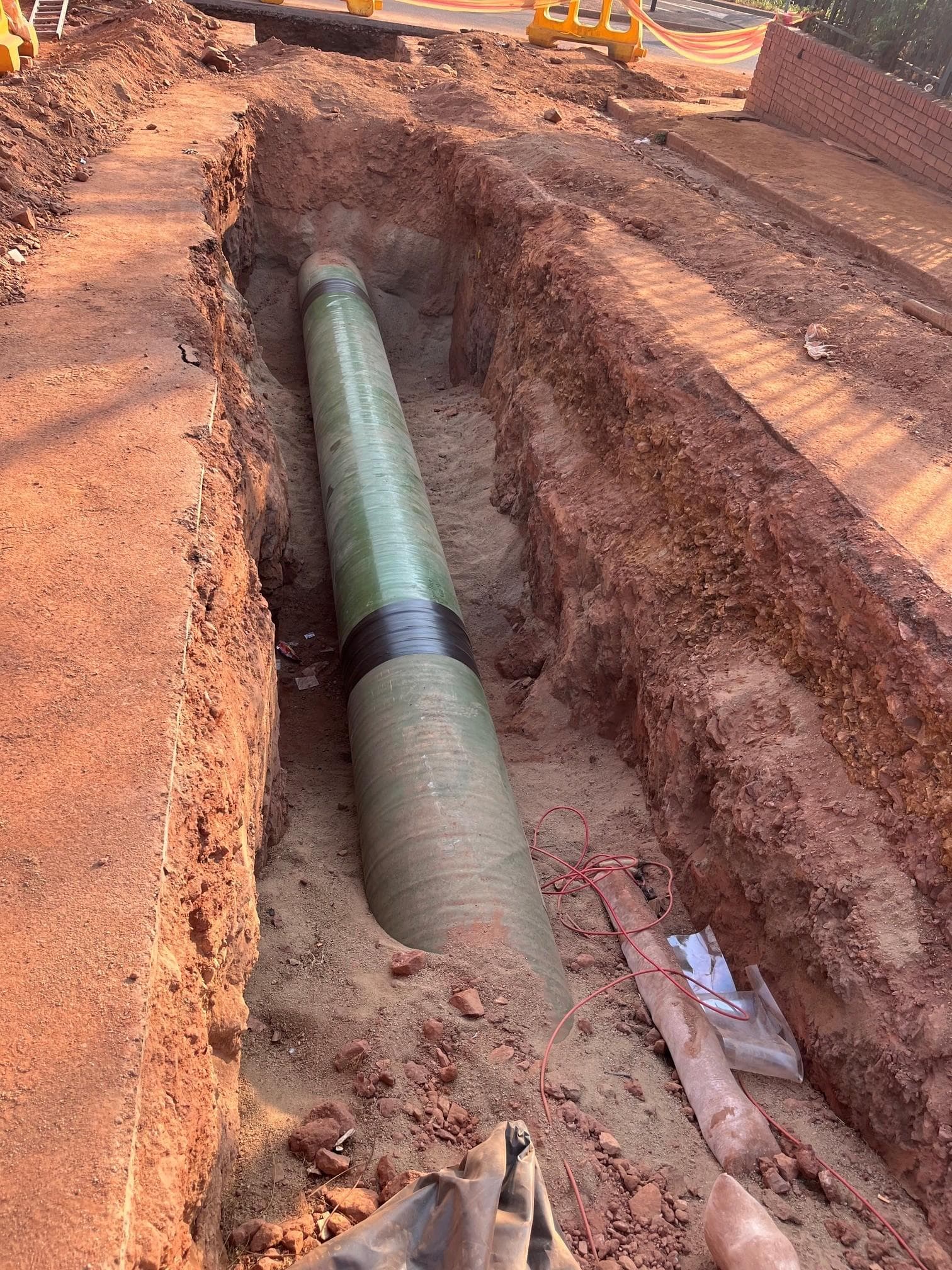 Glass-reinforced and steel pipe joint on sand bedding in the Crosby trench