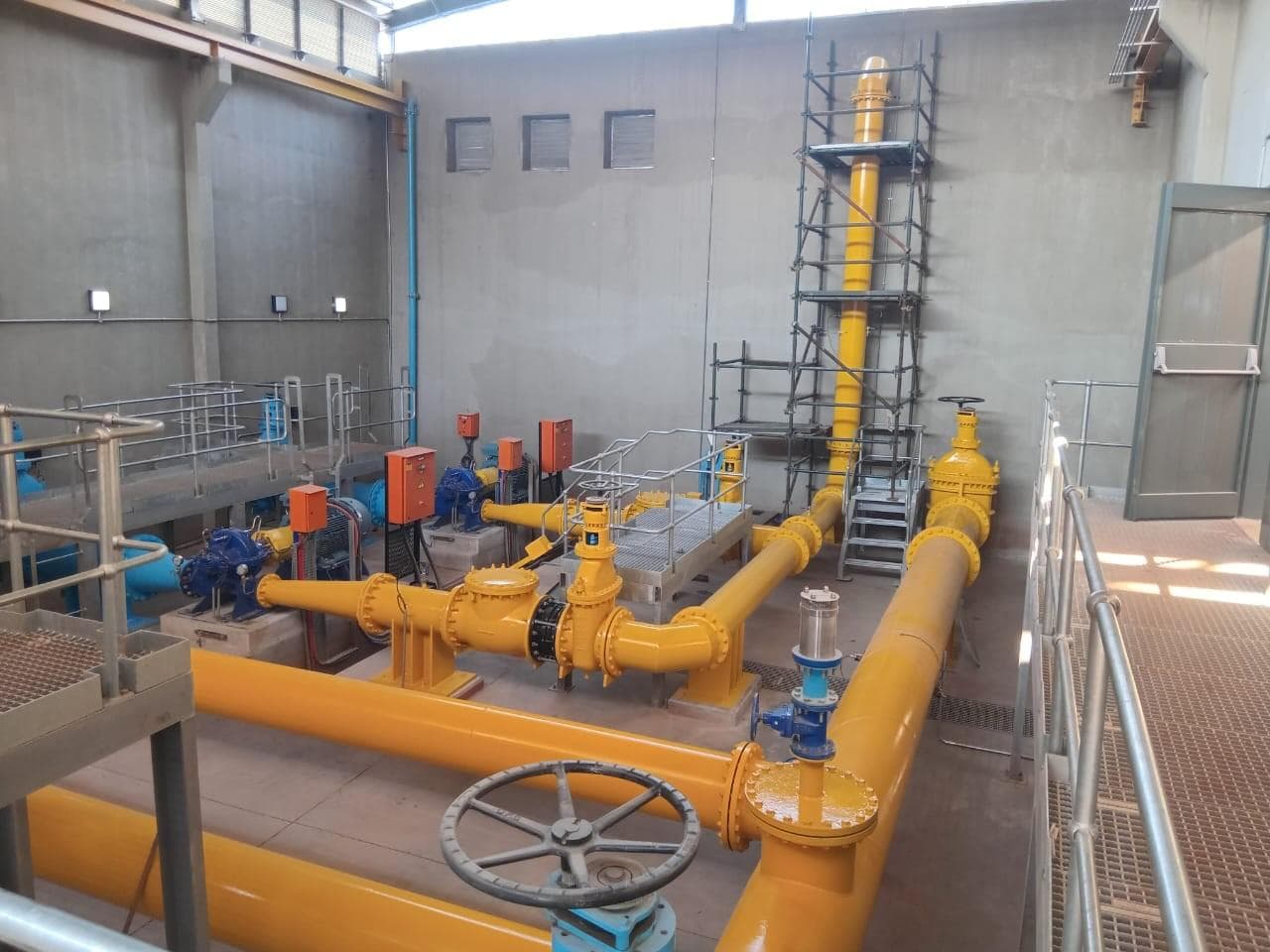 Yellow pipework and blue pumps inside the refurbished Crosby pump station