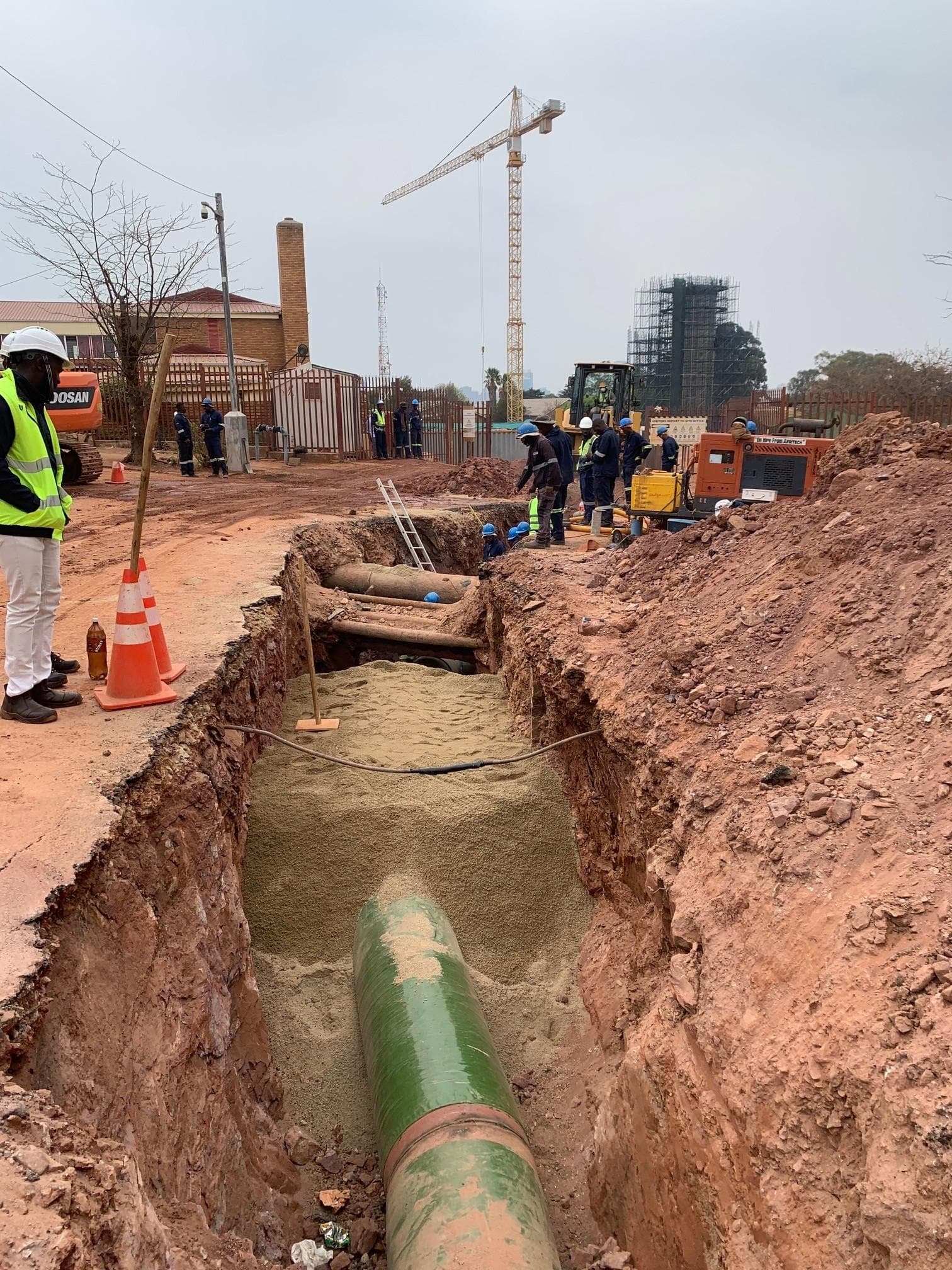 Site crew and excavator installing the Crosby steel pumping main